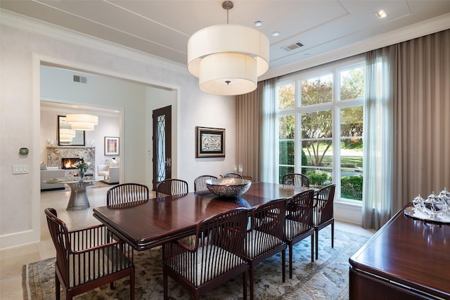 dining area featuring crown molding and a fireplace