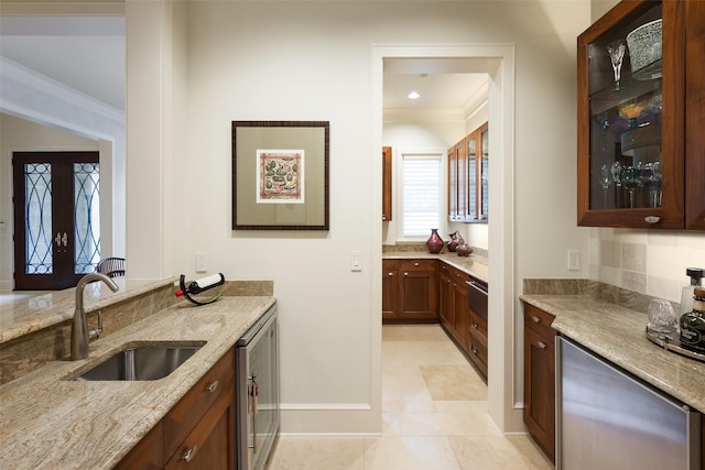 kitchen with sink, crown molding, light tile patterned flooring, and light stone counters