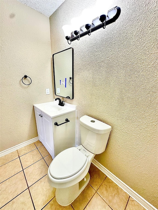 bathroom with toilet, tile patterned flooring, and vanity