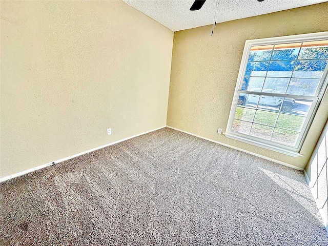 carpeted spare room featuring a textured ceiling and ceiling fan