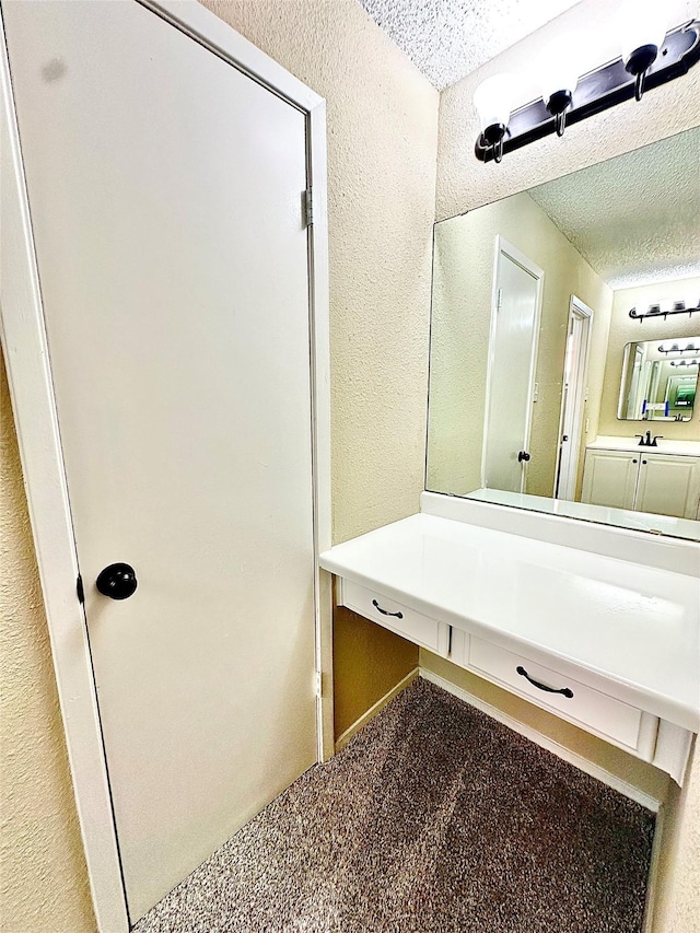 bathroom with a textured ceiling and vanity