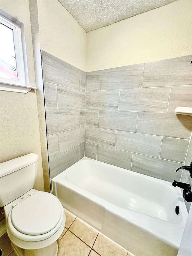 bathroom with toilet, tile patterned flooring, and a textured ceiling