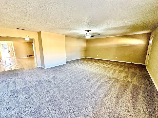 carpeted empty room with ceiling fan and a textured ceiling