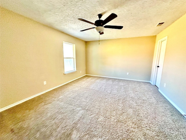 spare room featuring a textured ceiling, ceiling fan, and carpet