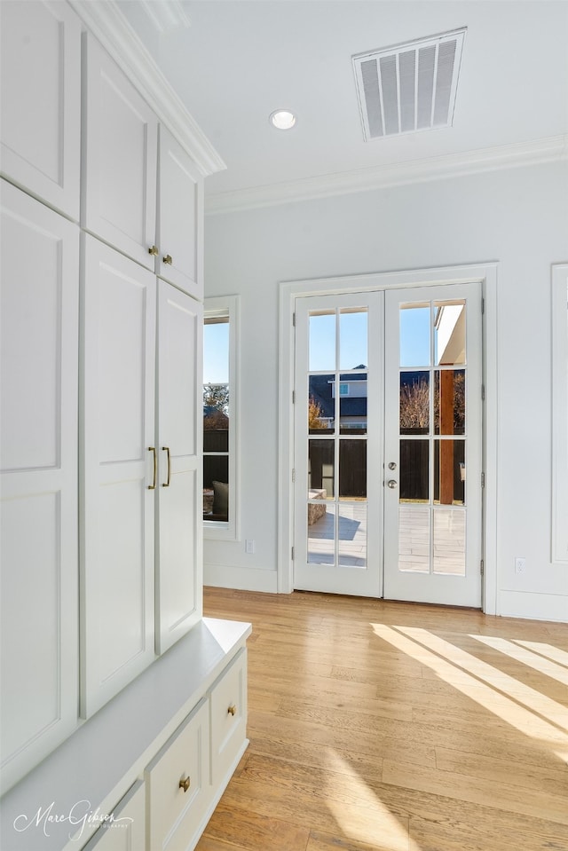 mudroom with ornamental molding, french doors, and light hardwood / wood-style floors