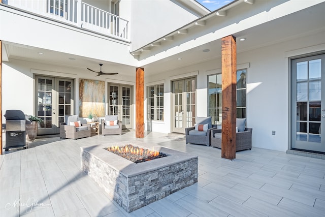 view of patio featuring an outdoor living space with a fire pit, ceiling fan, grilling area, and french doors