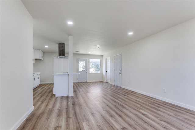 unfurnished living room featuring light wood-style flooring, baseboards, and recessed lighting