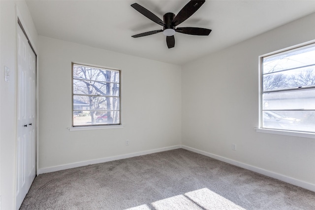 unfurnished bedroom featuring a ceiling fan, a closet, light carpet, and baseboards