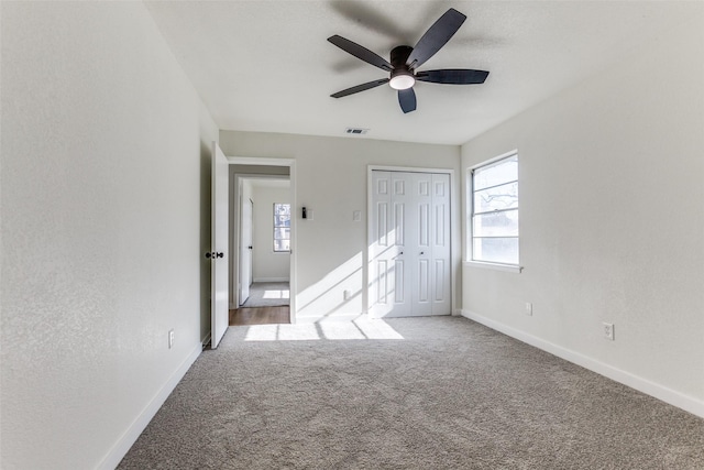 interior space featuring baseboards, a closet, visible vents, and light colored carpet