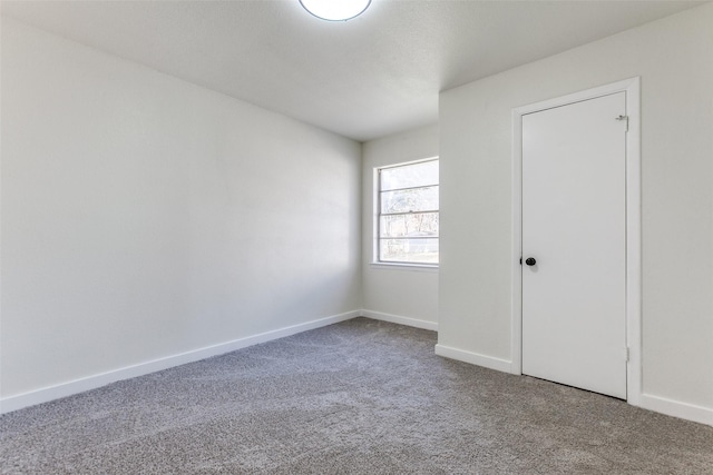 carpeted spare room with baseboards