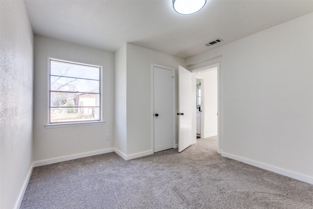 unfurnished bedroom with light carpet, visible vents, and baseboards