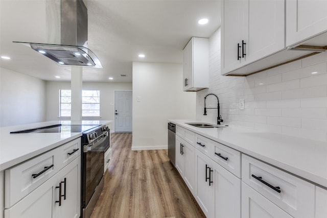 kitchen with stainless steel appliances, a sink, white cabinets, light countertops, and island exhaust hood