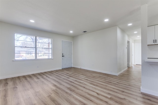 unfurnished room featuring light wood-style flooring, visible vents, baseboards, and recessed lighting