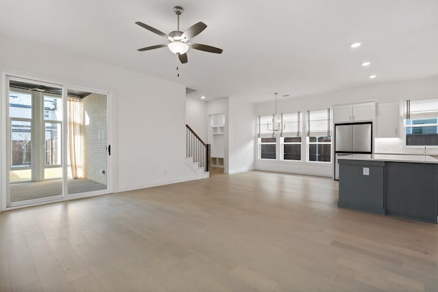 unfurnished living room featuring light wood-type flooring and ceiling fan