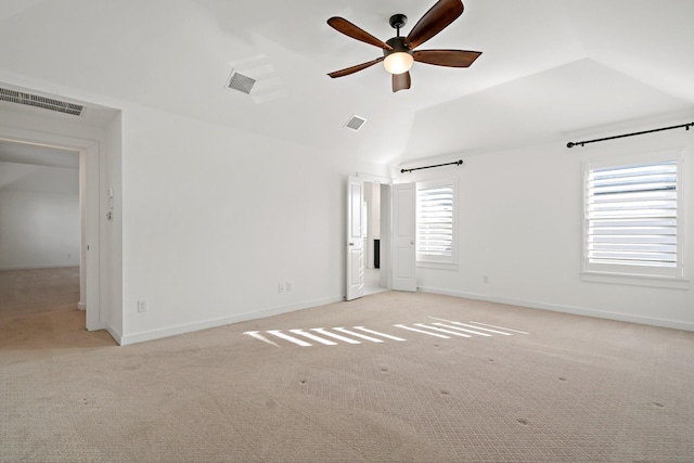 carpeted spare room featuring lofted ceiling and ceiling fan