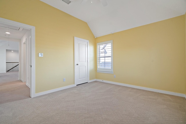 unfurnished bedroom with ceiling fan, vaulted ceiling, and light colored carpet