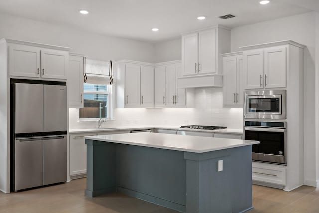 kitchen featuring white cabinetry, light wood-type flooring, a center island, and appliances with stainless steel finishes