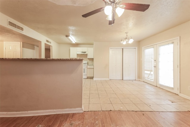 kitchen with white cabinets, ceiling fan with notable chandelier, french doors, and light hardwood / wood-style floors