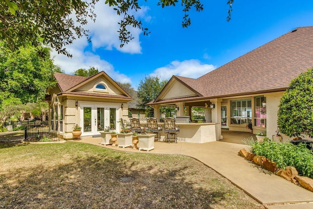 rear view of house with a bar, a patio, french doors, and a yard