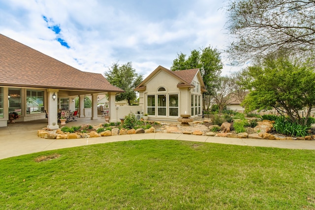 back of property featuring a yard and a patio