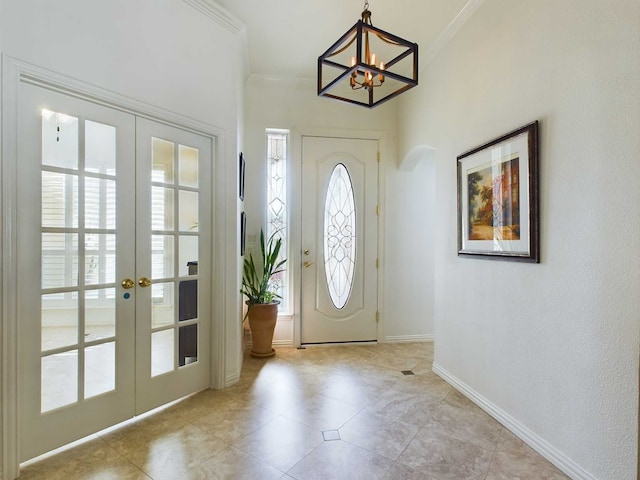 doorway featuring an inviting chandelier, french doors, and crown molding