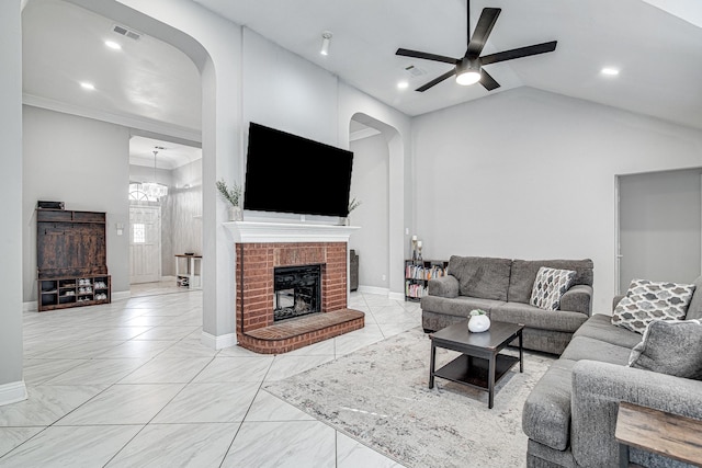 living room featuring ceiling fan with notable chandelier, high vaulted ceiling, and a brick fireplace