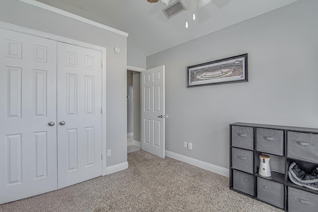 interior space featuring light carpet, a closet, and lofted ceiling