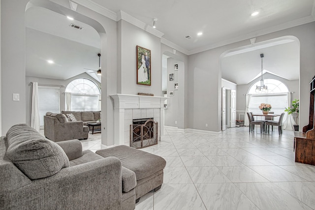 living room with a healthy amount of sunlight, ceiling fan with notable chandelier, ornamental molding, and a fireplace