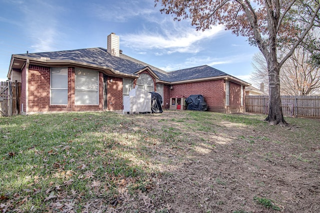 rear view of property featuring a lawn