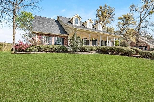 cape cod house with a porch and a front lawn