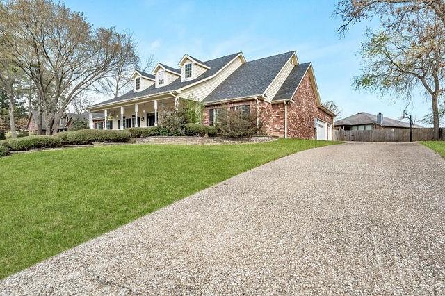 cape cod home featuring a front lawn