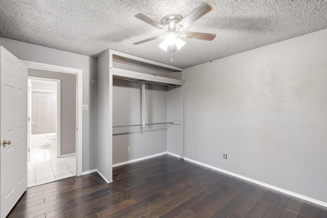 unfurnished bedroom with a textured ceiling, ceiling fan, a closet, and dark hardwood / wood-style floors