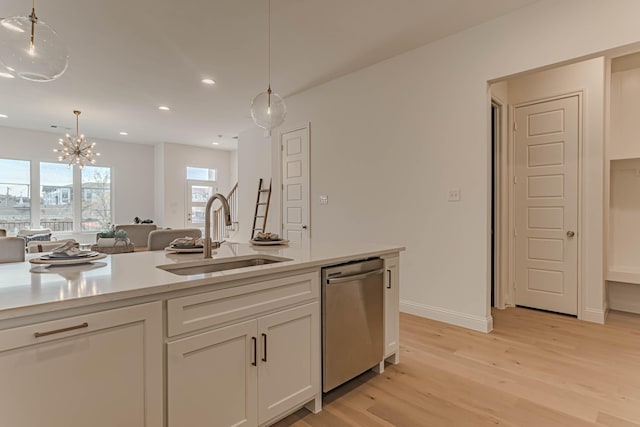 kitchen featuring white cabinets, an inviting chandelier, sink, decorative light fixtures, and stainless steel dishwasher