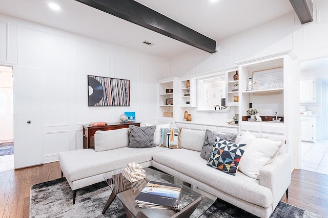 living room featuring light hardwood / wood-style flooring and beamed ceiling