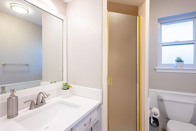 bathroom featuring toilet, an enclosed shower, and vanity