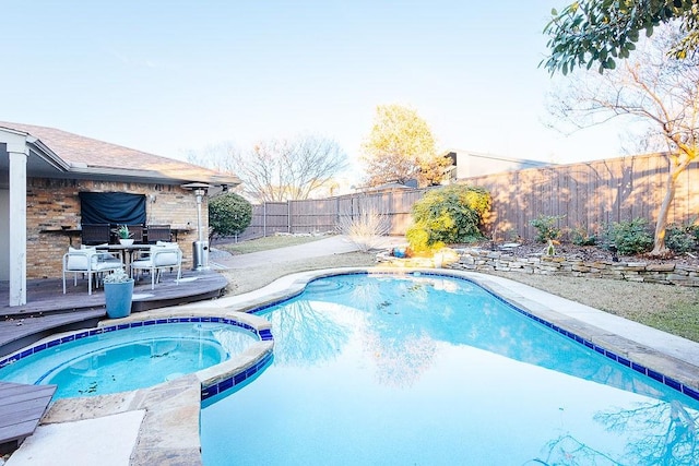 view of pool with an in ground hot tub and a wooden deck