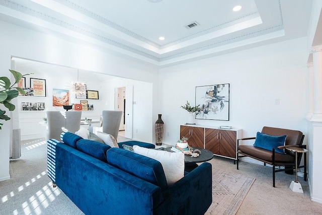 carpeted living room with a raised ceiling and crown molding