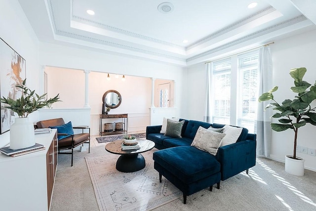 living room with ornamental molding, light carpet, a raised ceiling, and decorative columns