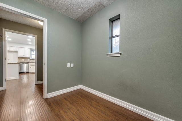 spare room with a textured ceiling and hardwood / wood-style floors