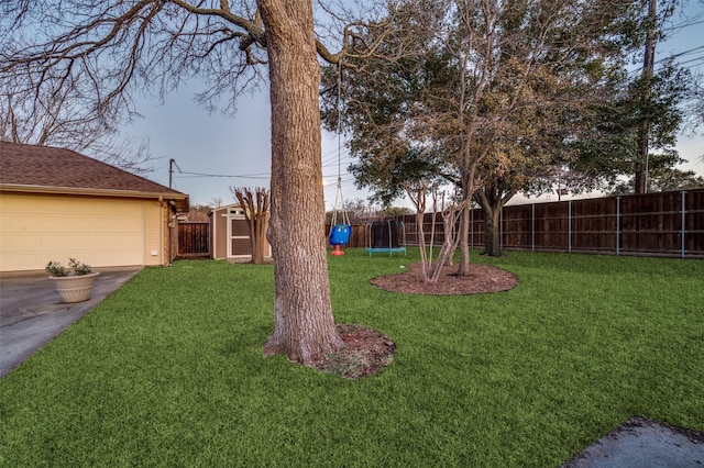 view of yard featuring a trampoline and a storage shed