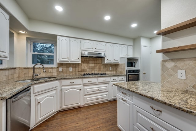 kitchen featuring white cabinets, stainless steel appliances, light stone counters, and sink