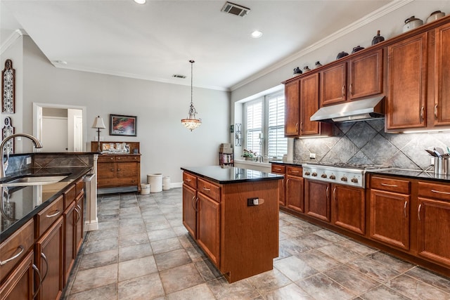 kitchen with pendant lighting, a center island, decorative backsplash, stainless steel gas cooktop, and sink