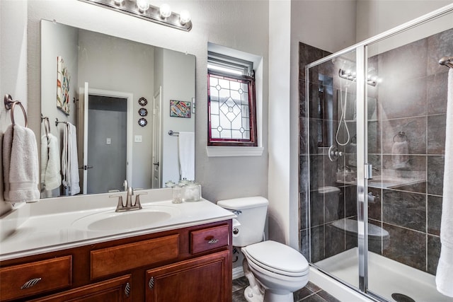 bathroom featuring walk in shower, vanity, and toilet