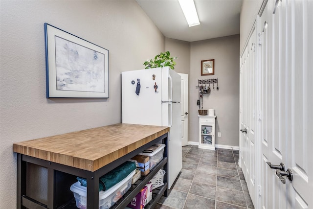 kitchen with white refrigerator and butcher block countertops