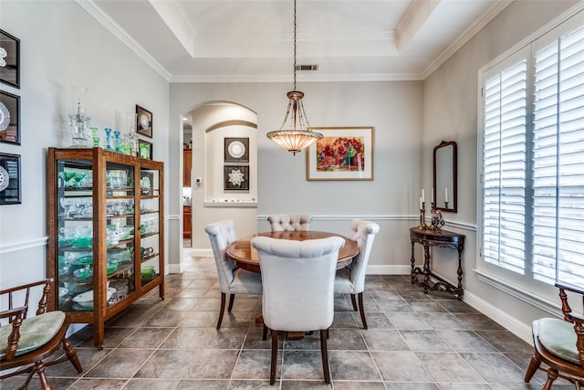 dining space featuring a tray ceiling, crown molding, and a healthy amount of sunlight