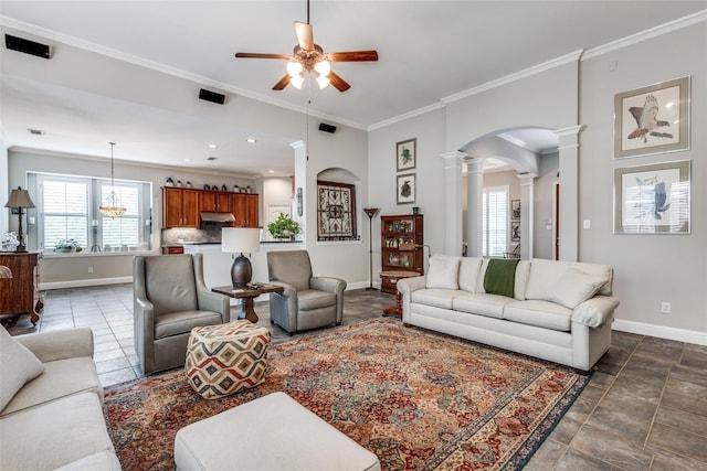 living room with ceiling fan, crown molding, and decorative columns