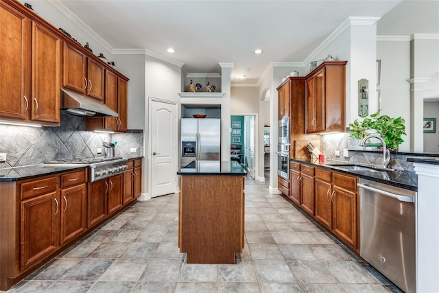 kitchen with stainless steel appliances, sink, tasteful backsplash, a kitchen island, and crown molding