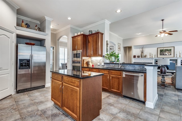 kitchen featuring kitchen peninsula, a kitchen island, appliances with stainless steel finishes, ceiling fan, and sink