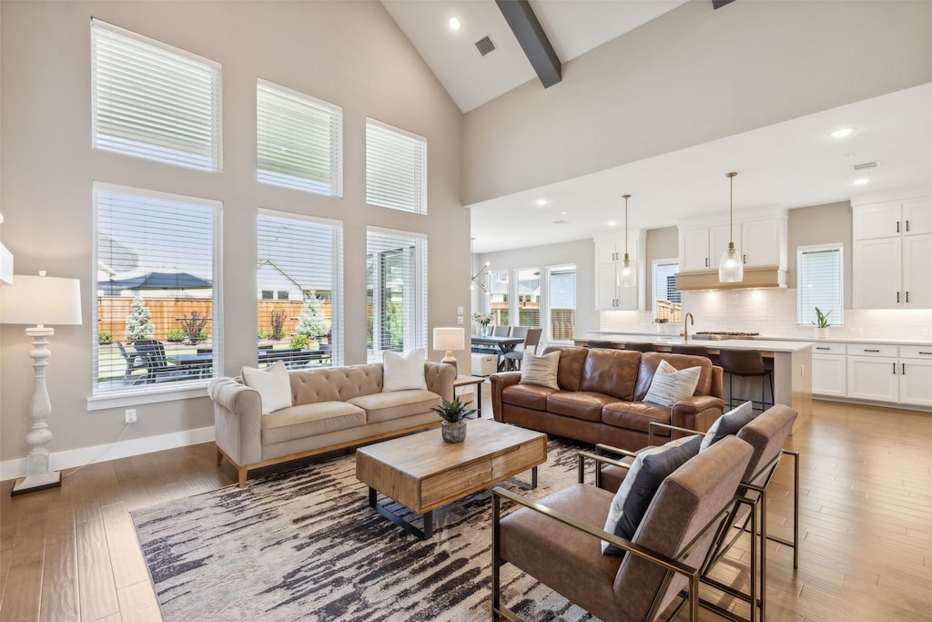 living room with high vaulted ceiling, wood-type flooring, and beamed ceiling