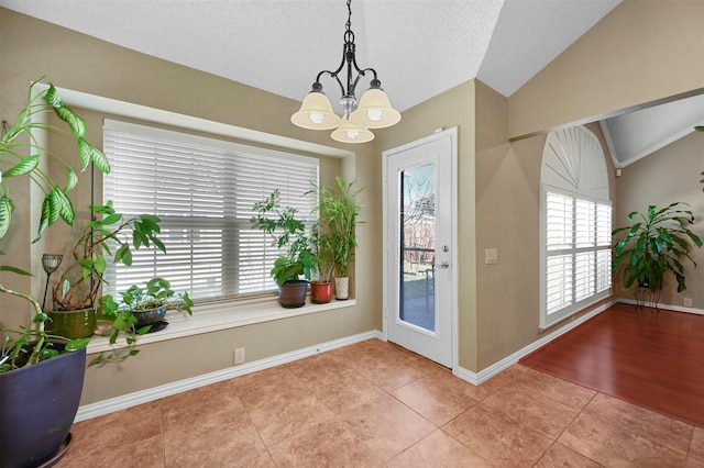 doorway to outside featuring lofted ceiling, tile patterned flooring, a textured ceiling, and an inviting chandelier